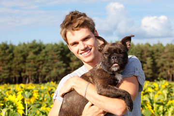 junger mann mit hund im arm
