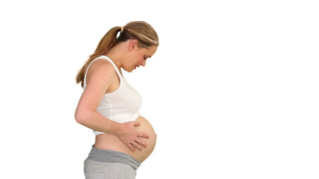 Pregnant woman touching her belly and she is smilling