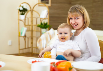 Fototapeta premium mother feeding her little son at home