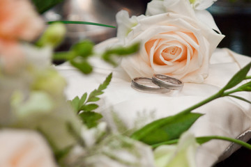 Two rings with rose on the small white pillow