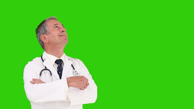 Mature doctor with stethoscope looking at the sky