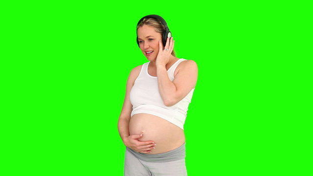 Blond pregnant woman listening to music