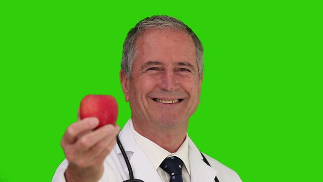 Doctor with a stethoscope holding an apple