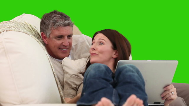 Mature couple using a laptop on their sofa