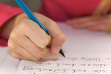 Kinderhand schreibt mit Bleistift close