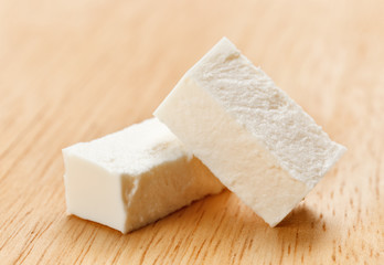 Feta cheese cubes with on wooden chopping board