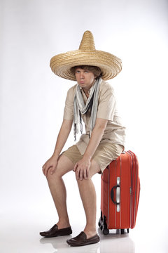 Very sad mexican man sitting on his luggage