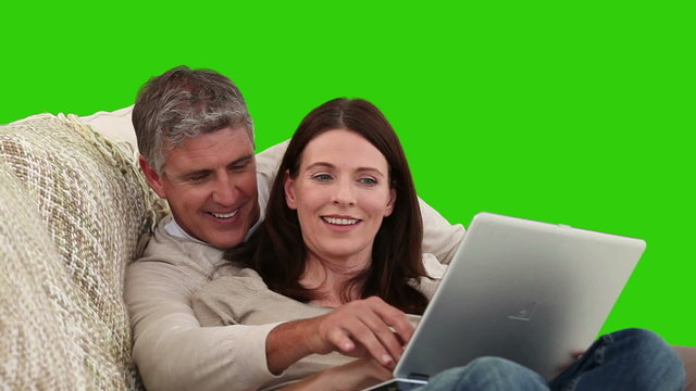 Elderly couple laughing in front of a laptop