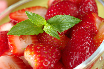 Mint leaf garnishing fresh half strawberries