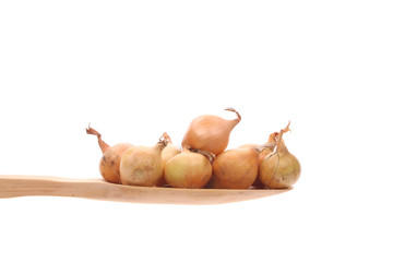 Onions on a wooden spoon isolated on a white background