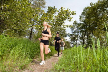 Obraz premium Three people running on pathway