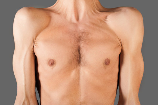 Part of skinny male torso. Isolated on gray.