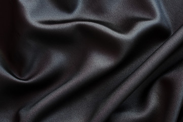 Photo d'un arrière-plan de tissu en soie ou satin noir, texture satinée, luxe et douceur