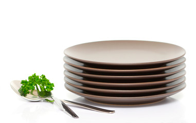 Plates, fork, spoon and parsley