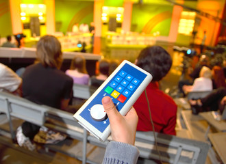 Voting device in boy's hands in auditorium