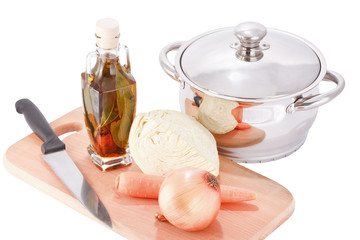 Stainless steel cooking pot and vegetables on chopping board