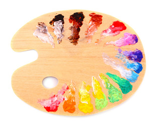 wooden art palette with blobs of paint and a brush on white back