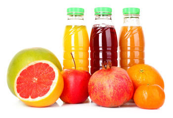 bottles of juice  with ripe fruits on white background