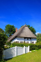 Fototapeta na wymiar Reetdachhaus Haus im grünen, Gartenzaun