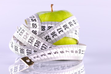 green apple surrounded by white tapeline on white