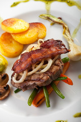 Speck auf ein Steak mit Gemüse