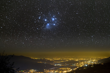 The Universe above city lights. The Pleiades star cluster.