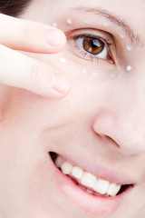Women applying eye skin cream