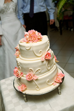 Traditional wedding cake in front of couple