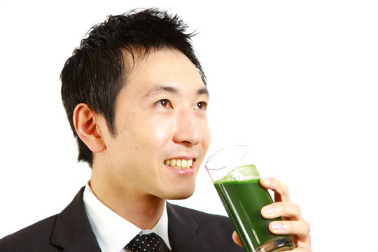 japanese businessman drinks green vegetable juice