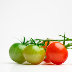 green and red cherry tomatoes on white