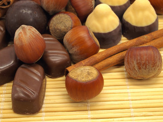 Cinnamon sticks, chocolate candies and hazelnuts