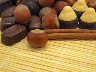 Cinnamon sticks, chocolate candies and hazelnuts