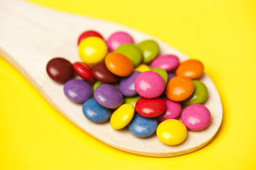 Schokolinsen auf einem Holzlöffel