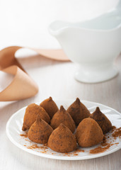 Chocolate truffles on a white plate on the table