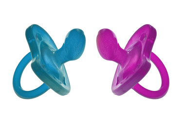 Colorful pair of dummies (or pacifiers), on white. Boy girl.
