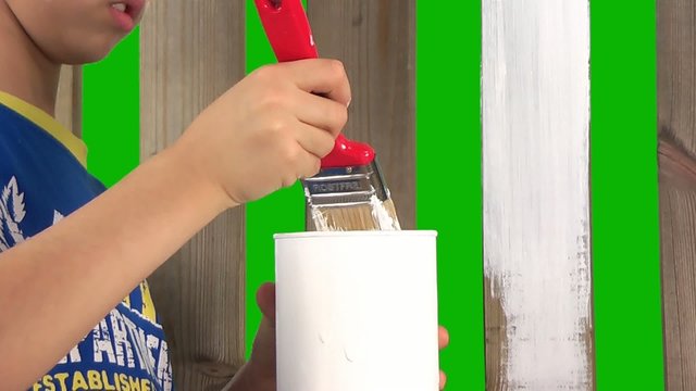 boy painting wooden fence