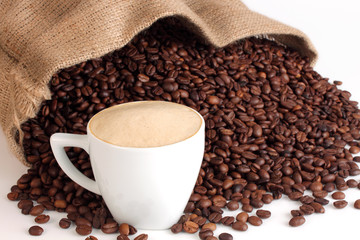 saco lleno de café con taza sobre un fondo blanco