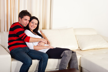 Fototapeta na wymiar Young couple in love on sofa home