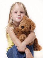 Girl with shy expression with her teddy bear.