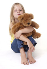 Girl with teddy bear with a neutral expression