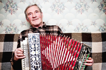 Elderly man playing on a musical instrument