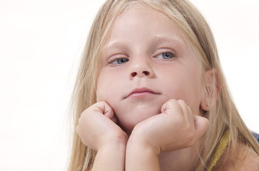 Little girl with face in hands and a neutral expression.