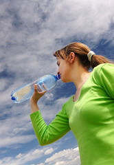 Woman drinking bottled water outside