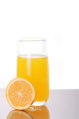 Fresh orange juice in a glass with a half orange