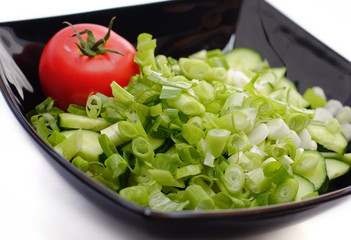 Onion  and tomato in black bowl