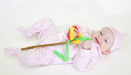 lying down baby girl holding a willow stick (Czech Easter)
