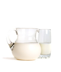 Pitcher and glass of milk on a white background.
