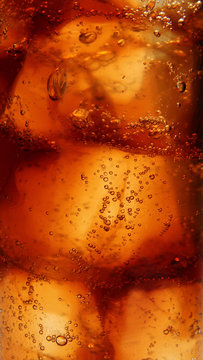 Cola with ice cubes close-up