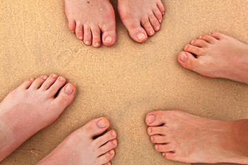 feet opf small family at the beach