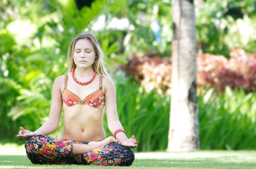 young beautiful woman meditating on natural background